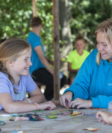 Niños realizan manualidades en una mesa en el Camping Sevink Molen, parque vacacional en Gelderland, Países Bajos.