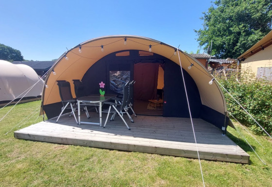 Tenda tunnel Sevink al Camping Sevink Molen nei Paesi Bassi con terrazza in legno, tavolo e sedie