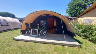 Tunnel tent Sevink at Camping Sevink Molen in the Netherlands with a wooden deck, table and chairs