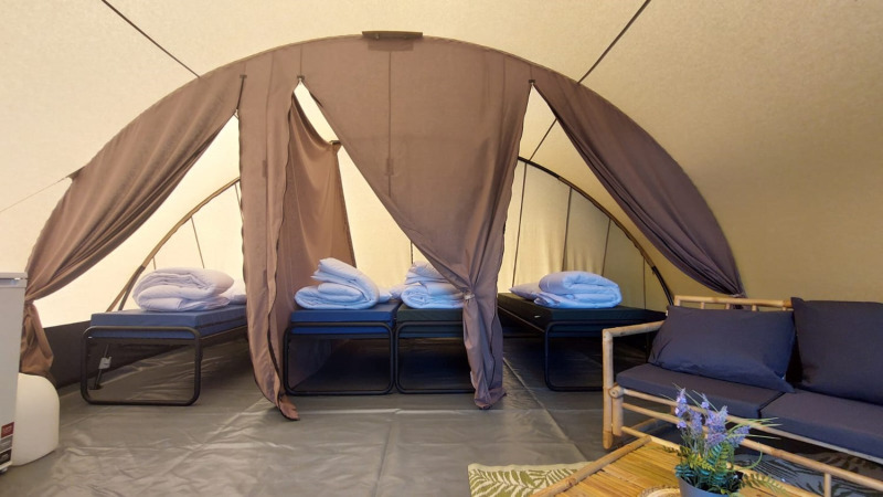 Interior de la tienda Tunnel Sevink en Camping Sevink Molen, Países Bajos, con camas y zona de descanso.