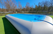 Piscina gonfiabile al Camping Het Veen, un villaggio turistico ad Anversa, Belgio, con alberi attorno.