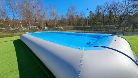 Inflatable swimming pool at Camping Het Veen holiday park in Antwerp, Belgium, surrounded by trees.