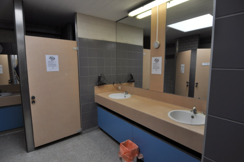 Bagno pubblico con lavandini, specchi e cabine al Camping Het Veen, parco vacanze ad Anversa, Belgio.