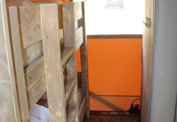 Interieur van een safaritent bij Lac du Causse in Frankrijk, met stapelbedden en houten vloer.