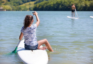 Personne assise sur une planche au Lac du Causse, Nouvelle-Aquitaine, France, par une journée ensoleillée.