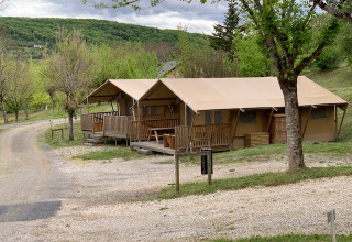 Trætelte og grønne omgivelser i Lac du Causse feriepark i Nouvelle-Aquitaine, Frankrig, på en overskyet dag.