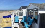 Strandhaus mit blauen Stühlen, Blick auf Sandstrand und Meer in Dishoek, Zeeland, Niederlande.
