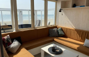 Sala luminosa en Beach house 'Dishoek 345/346', con grandes ventanas al mar y la playa en Zeeland, Países Bajos.
