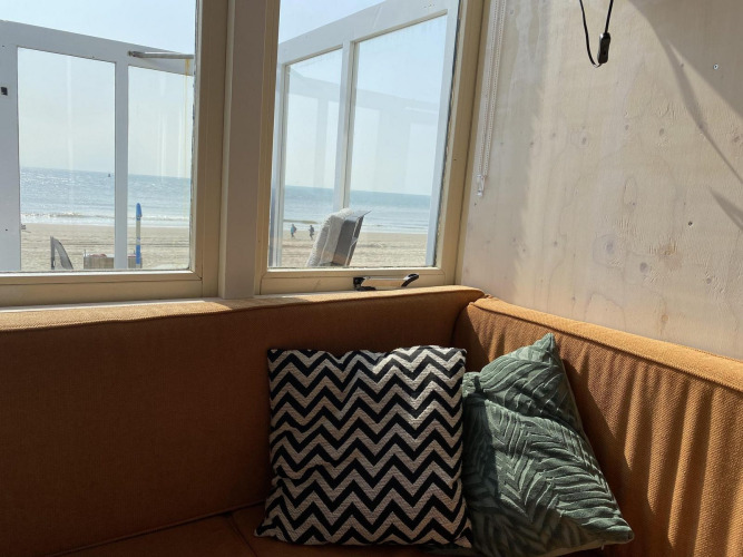 Gezellige hoekbank met kussens en strandzicht bij Beach house 'Dishoek 345/346' in Zeeland, Nederland.
