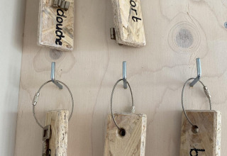 Tablero de llaves con grandes etiquetas de madera y llaves en Beach House 'Dishoek' en Zeeland, Países Bajos.
