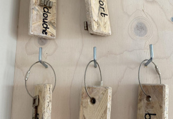 Tablero de llaves con grandes etiquetas de madera y llaves en Beach House 'Dishoek' en Zeeland, Países Bajos.