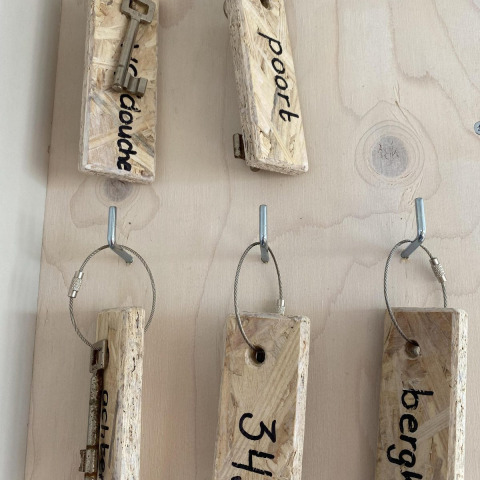 Portachiavi con grandi etichette di legno e chiavi nella cabina Beach House 'Dishoek' a Zeeland, Olanda.