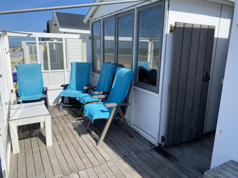 Terrasse des Strandhauses Dishoek 345/346 mit blauen Stühlen bei Welcome.in in Zeeland, Niederlande.