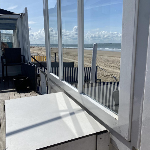 Beach cabin overlooking sandy beach and sea at Beach house 'Dishoek 345/346' in Zeeland, Netherlands.