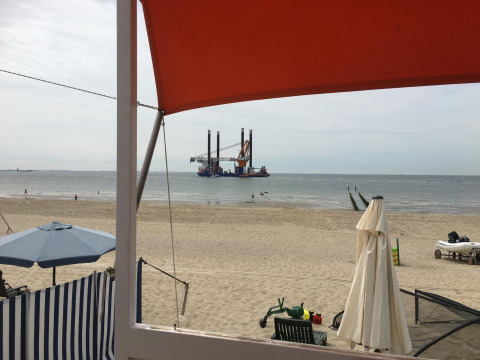 Uitzicht vanuit Beach house Dishoek 345/346 te Zeeland, Nederland, met strand, zee en een boorplatform.