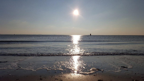 Coucher de soleil sur la mer depuis Beach House Dishoek 345/346, Zélande, Pays-Bas, avec de douces vagues.
