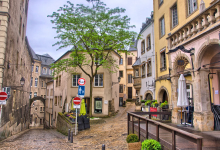 Calles empedradas y edificios históricos pintorescos en Wallendorf-pont, Diekirch, Luxemburgo, rodeados de árboles.