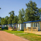 Moderne Lodge XL hytter på Vakantiepark Bergumermeer i Holland omgivet af grønne træer og blomster.