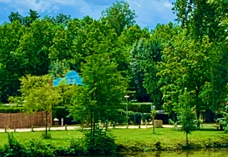 Uitzicht op het meer en Camping Paradis Aubeterre, omgeven door bomen in Nouvelle-Aquitaine, Frankrijk.
