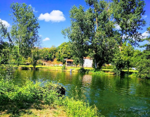 Vista pintoresca del lago y árboles en Camping Paradis Aubeterre, un parque vacacional en Nouvelle-Aquitaine, Francia.