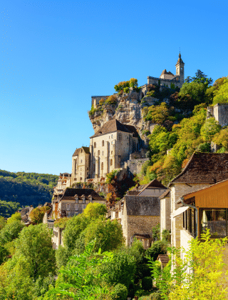Pueblo en la cima de una colina con edificios históricos de piedra y vegetación, cerca de Lissac-sur-Couze.