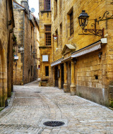 Callejuela empedrada bordeada de antiguos edificios de piedra cerca de Lissac-sur-Couze, en Nueva Aquitania, Francia.
