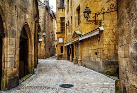 Callejuela empedrada bordeada de antiguos edificios de piedra cerca de Lissac-sur-Couze, en Nueva Aquitania, Francia.