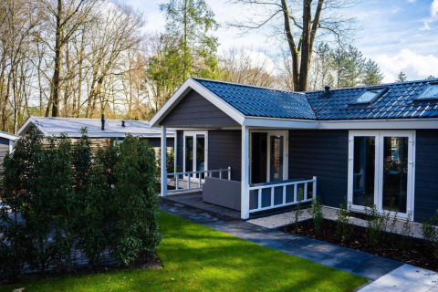 Moderne Heuvelrug Cottage med terrasse og grøn have ved De Thijmse Berg, Holland, set i fredelige omgivelser.