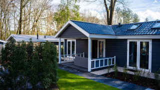 Cottage Heuvelrug moderno con patio e giardino verde a De Thijmse Berg, Paesi Bassi, immerso nella natura.