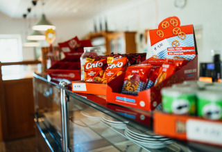 Snacks og pretzels i farverige pakker på en glasmonter i Paradies Camp, feriepark i Rheinland-Pfalz, Tyskland.