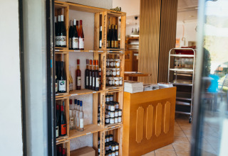 Hyggelig butik i Paradies Camp, Rheinland-Pfalz, Tyskland, med hylder af vinflasker og lokale produkter.