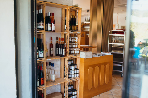 Étagères de bouteilles de vin et produits locaux dans une boutique du Paradies Camp, Rhénanie-Palatinat, Allemagne.
