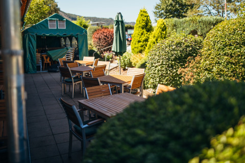 Außenbereich mit Sitzplätzen im Paradies Camp, Ferienpark in Rheinland-Pfalz, Deutschland, umgeben von Grün.
