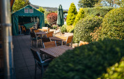 Outdoor dining area at Paradies Camp holiday park in Rhineland-Palatinate, Germany, surrounded by greenery.