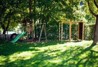 Aire de jeux avec toboggan et balançoires au Paradies Camp, un parc de vacances en Rhénanie-Palatinat, Allemagne.