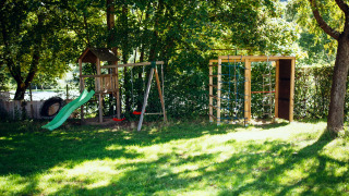 Parque infantil con tobogán y columpios en Paradies Camp, un parque vacacional en Renania-Palatinado, Alemania.