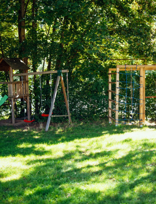 Parque infantil con tobogán y columpios en Paradies Camp, un parque vacacional en Renania-Palatinado, Alemania.