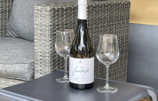Bottiglia di vino bianco e due bicchieri su tavolo in tenda safari al Camping le Mas de Mourgues, Francia.