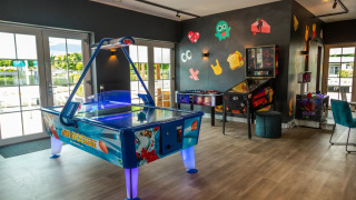 Sala de juegos en un parque vacacional con glamping, con hockey de aire, futbolín y pinball.