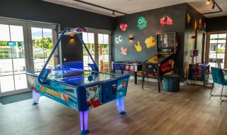 Sala de juegos en un parque vacacional con glamping, con hockey de aire, futbolín y pinball.