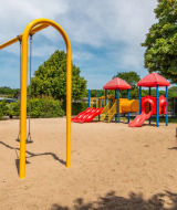 Parque infantil con columpios y toboganes en un parque vacacional con alojamientos glamping, día soleado