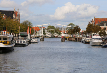 Foto di un canale con barche e ponte olandese in un parco vacanze che offre alloggi glamping.