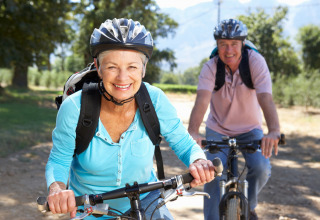 Pareja mayor en bici en la naturaleza en Camping & Ferienpark Brilon, Renania del Norte-Westfalia, Alemania.