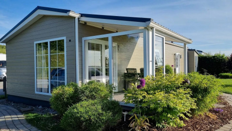 Modern vakantiehuis met grote ramen en tuin bij Camping & Ferienpark Brilon in Noordrijn-Westfalen, Duitsland.