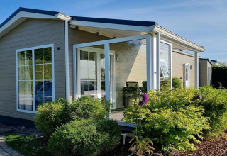 Moderne feriebolig med store vinduer og have, set på Camping & Ferienpark Brilon i Nordrhein-Westfalen, Tyskland.