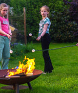 Niños asan malvaviscos sobre una fogata en Mini Camping Drentse Monden, un parque vacacional en Drenthe, Países Bajos.