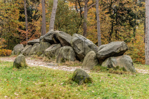 Prehistorische hunebed tussen de bomen bij Mini Camping Drentse Monden, Drenthe, Nederland in de herfst.