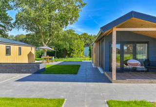 Moderne vakantiehuizen met terras en grasveld in Drentse Weelde vakantiepark, Drenthe, Nederland.