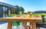 Udendørs træbord dækket med croissanter, juice og vin i ferieparken Drentse Weelde, Drenthe, Holland.