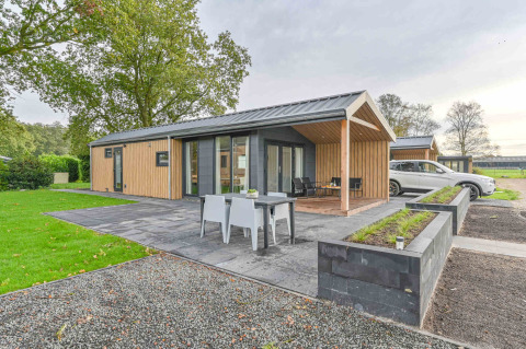 Casa de vacaciones moderna en Drentse Weelde, un parque vacacional en Drenthe, Países Bajos, con terraza y jardín.